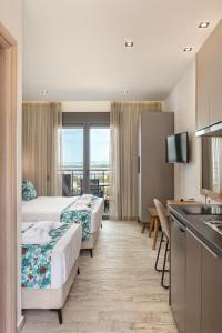 a hotel room with two beds and a kitchen at THEA Luxury Apartments in Vourvourou