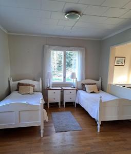 um quarto com 2 camas e uma janela em Norrby Gård - Sjövik em Raseborg