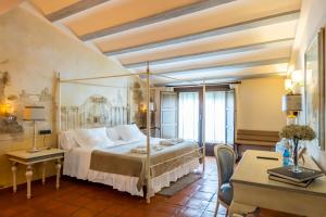 un dormitorio con una cama y un escritorio en YIT La Casona del Arco, en Baeza