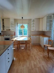 a kitchen with white cabinets and a table and chairs at Norrby Gård - Sjövik in Raseborg