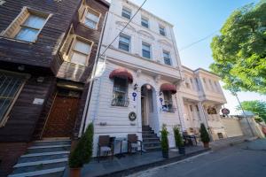ein weißes Haus mit Stühlen und Tischen davor in der Unterkunft Solomon's Mansion Hotel Istanbul in Istanbul