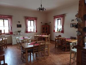 a dining room with tables and chairs and windows at Hospůdka Na Trucovně in Sázava