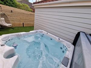 a hot tub in the backyard of a house at Sunny Side Tropical Hideaway in Cromer