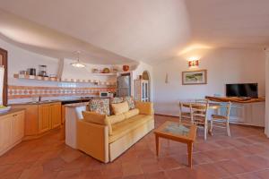 a kitchen and living room with a couch and a table at Villetta Bomboniera in Arzachena
