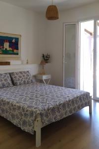 een slaapkamer met een bed met een blauw dekbed bij B&B Il Carlino in Villaggio Azzurro