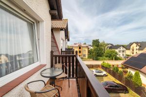 a balcony with chairs and a table and a view of a street at Nord Jastarnia bis in Jastarnia
