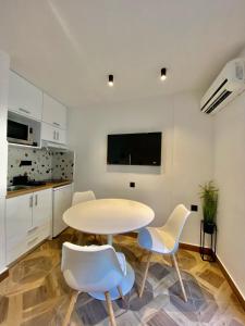 a white kitchen with a table and two chairs at Sunshine Cozy Central Studio Basement in Heraklio
