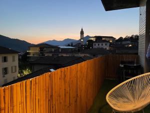 a balcony with a wooden fence and a chair at Green House Calolziocorte in Calolziocorte