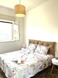una camera da letto con un letto con copriletto floreale e una finestra di Villetta con Oliveto CFG a Prizzi