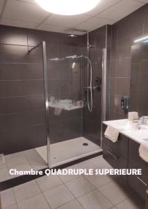 ein Bad mit einer Dusche und einem Waschbecken in der Unterkunft Hôtel Terminus - Pizzeria Pizz'a gogo - salle de sport - face à la gare in Lons-le-Saunier