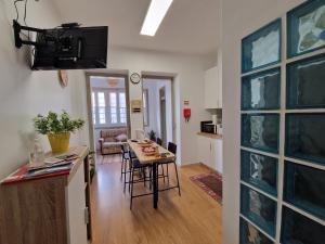 a kitchen and a living room with a table and chairs at Casa Mosteiro in Alcobaça