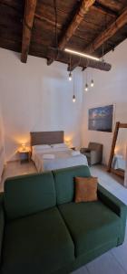 a bedroom with a bed and a green couch at NANNI LOFT HOUSE in Castellammare di Stabia