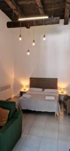 a bedroom with a bed and a green couch at NANNI LOFT HOUSE in Castellammare di Stabia
