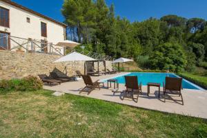 einen Pool mit Stühlen und Sonnenschirmen neben einem Haus in der Unterkunft Villa Fraiano in Palaia