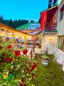 a garden with flowers and lights in front of a building at Hotel Forest Star on the Ski Slope in Borovets