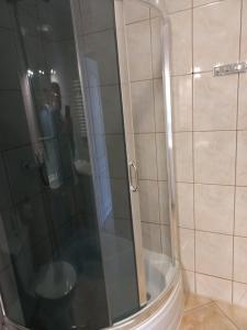 un uomo che scatta una foto di una doccia in bagno di Kołobrzeg Apartamenty Monada, Towarowa 50m od morza a Kołobrzeg