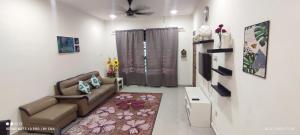 a living room with a couch and a tv at Izora Homestay in Kampong Pengkalan Maras
