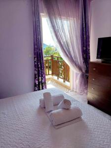 a bedroom with a bed with towels and a window at Nefeli Maisonette in Nikiti