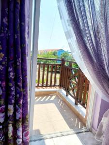 a view of a balcony from a window with curtains at Nefeli Maisonette in Nikiti