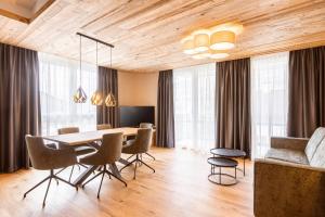 uma sala de jantar com um tecto de madeira e uma mesa e cadeiras em Zillertal Suites Fügen by ALPS RESORTS em Fügen