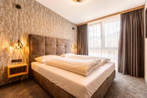 เตียงในห้องที่ Zillertal Suites Fügen by ALPS RESORTS