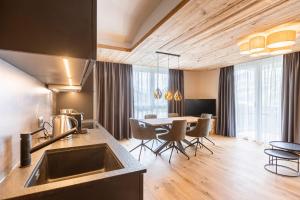 Zillertal Suites Fügen by ALPS RESORTS في فوغين: مطبخ وغرفة طعام مع طاولة وكراسي