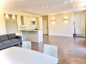 a living room with a couch and a table and a kitchen at Luxuries 2 Bed Room Flat in Canary Wharf in London