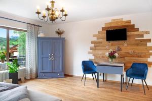 a living room with a table and blue chairs at Aschaubichl - Wohnung Enzian in Grainau