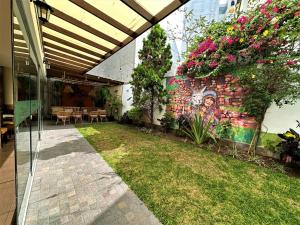 a garden with a painting on the side of a building at El Tambo 1 in Lima