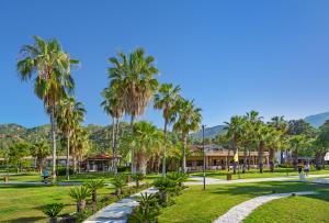 um parque com palmeiras e uma passarela em Rixos Premium Göcek - Adult Only em Göcek