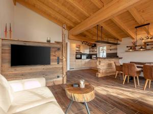 a living room with a couch and a tv and a table at Holiday home in Uttendorf in the mountains in Uttendorf