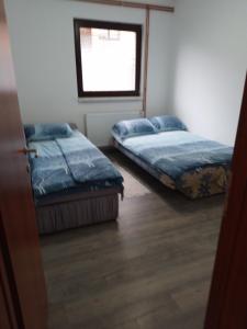 two beds in a room with a window at Apartman Uros in Pale