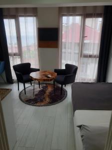 a living room with a table and chairs and windows at Sıla Apart Otel in Bostancı
