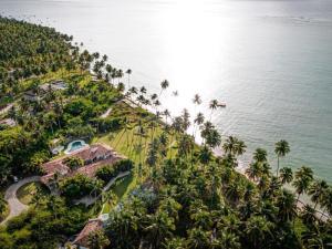 una vista aérea de un complejo con palmeras y el océano en Casa Brasileira - Hotel Galeria en Pôrto de Pedras