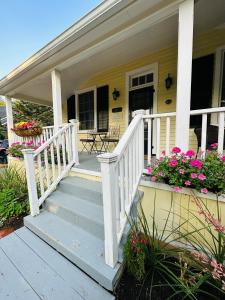 a porch with white railings and flowers on a house at Heritage House Niagara in Niagara on the Lake
