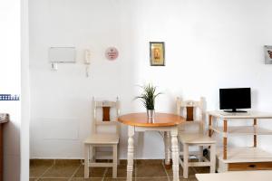 コニル・デ・ラ・フロンテーラにあるEstudio Pacifico 201のテーブルと椅子、テレビが備わる客室です。