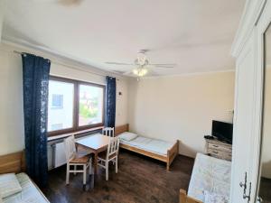 Zimmer mit einem Tisch, einem Bett und einem Fenster in der Unterkunft Hostel Rumiankowy Airport Hostel in Breslau