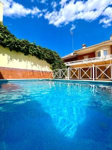 una gran piscina azul junto a un edificio en La casa de María, en Linares