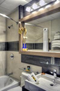 y baño con lavabo, aseo y espejo. en Hotel Continental Centre-Ville, en Val-dʼOr