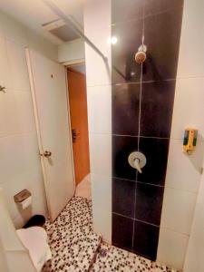 La salle de bains est pourvue d'une douche et de toilettes. dans l'établissement Studio One Thamrin Hotel, à Jakarta
