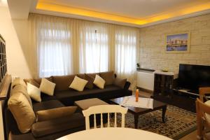 - un salon avec un canapé et une télévision dans l'établissement Margarita Guest House, à Berat