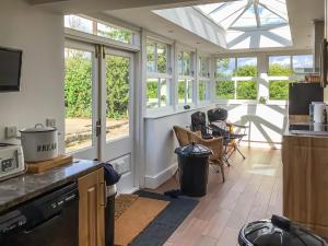 a kitchen with a conservatory with windows at The Croft in Longhorsley