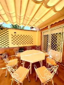 eine Terrasse mit einem Tisch und Stühlen unter Markise in der Unterkunft La casa de María in Linares