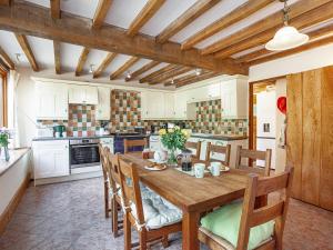 a large kitchen with a wooden table and chairs at Pondmead in Monk Okehampton