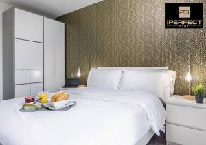 a white bed with a tray of food on it at Manhattan Apartment City Centre By Your Perfect Stay short lets Birmingham in Birmingham