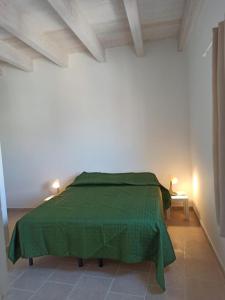 a bedroom with a green bed in a white room at Cara Casa al Porto n.25 in Bari