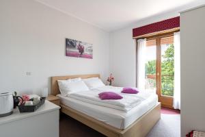 カヴァレーノにあるPiccolo Orso Brunoのベッドルーム1室(紫色の枕が付いたベッド1台付)