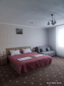 1 dormitorio con 1 cama grande y 1 sofá en Apart-hotel 24/7, en Kamianets-Podilskyi