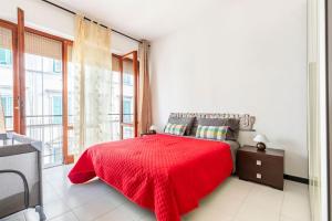 Schlafzimmer mit einem roten Bett und einem großen Fenster in der Unterkunft Casa Etruschi - Appartamento con posto auto in Livorno