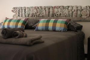 een bed met twee kussens en een deken erop bij Casa Etruschi - Appartamento con posto auto in Livorno